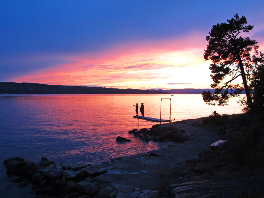 Beautiful sunset near Ingierstrand, just outside of Oslo, Norway. Irene and Hilde on jetty.