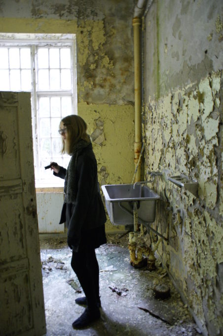 Alice looking for interesting things in an old kitchen